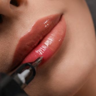 Young woman undergoing procedure of permanent lip makeup in tattoo salon, top view
